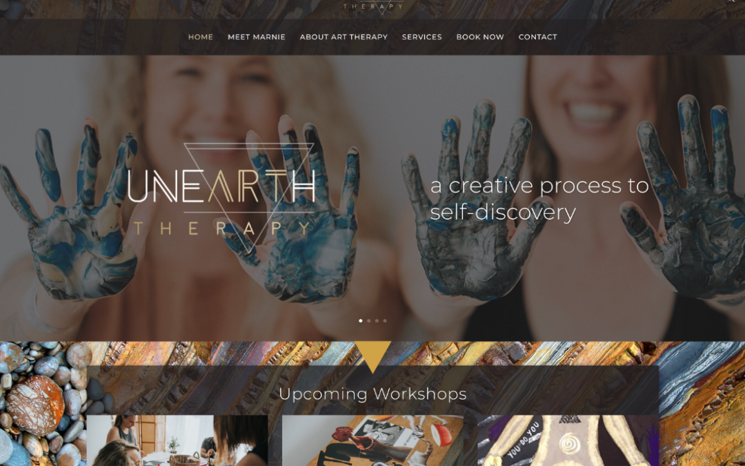 An art therapy website built for Marnie Delanghe. Two people stand smiling at the camera, with paint on their hands.