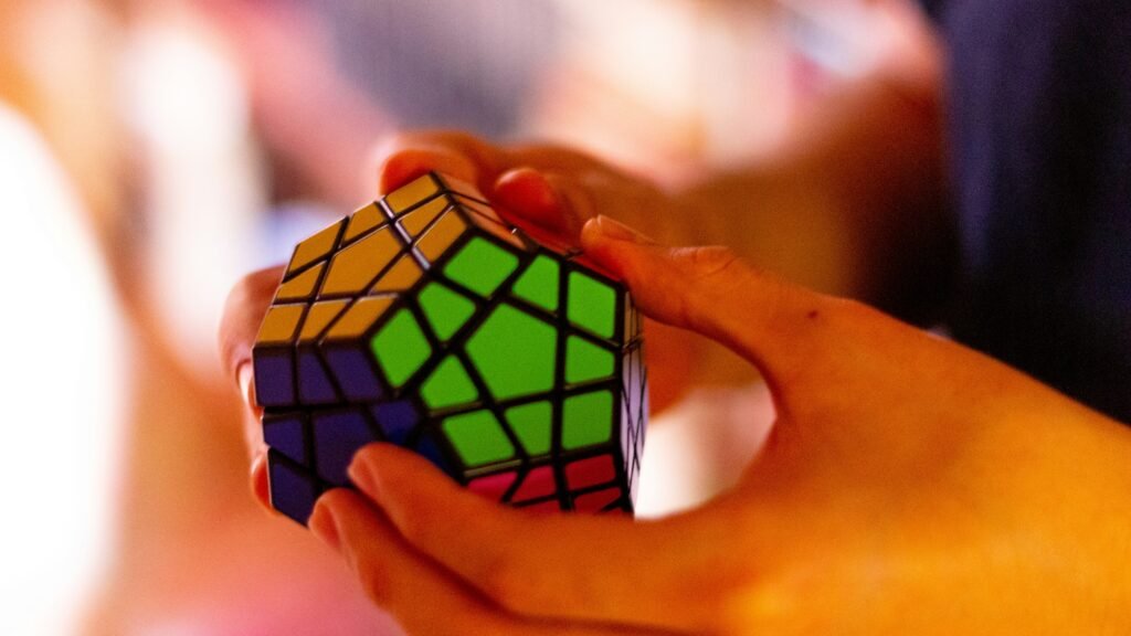 A closeup of a person solving a complex rubik cube. The colours are warm, and the cube has more than four sides. This is for an article about SEO