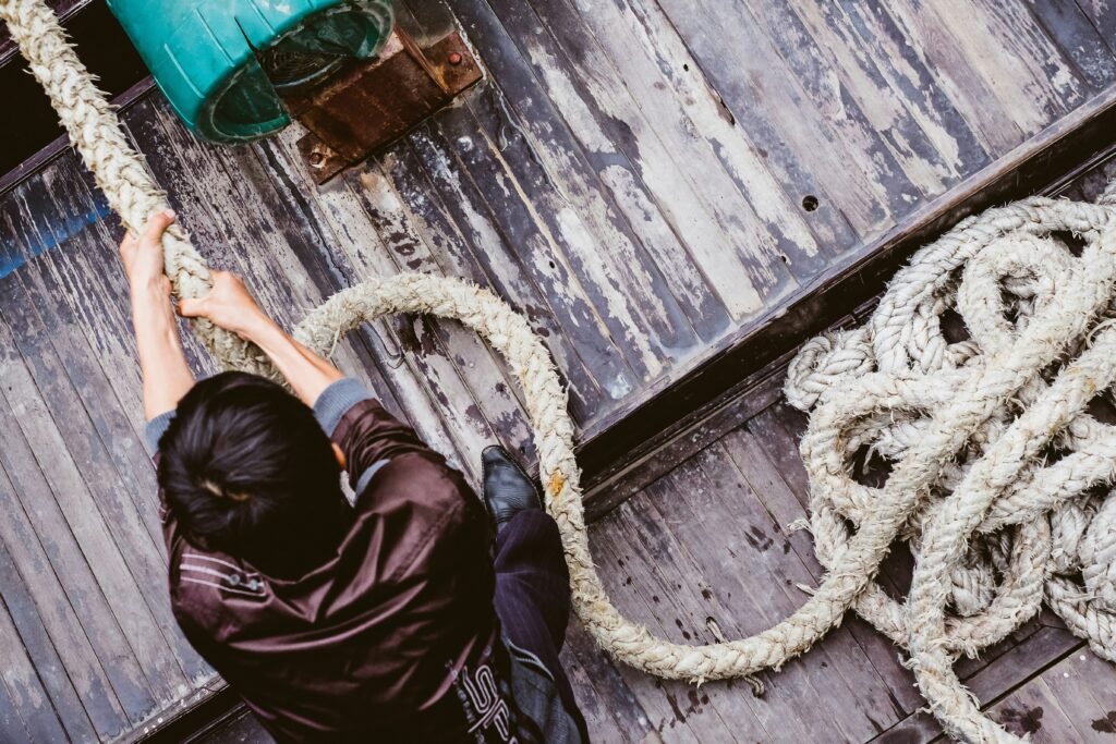 a person wearing a leather style jacket pulls a rope towards them. This is for an article about assertiveness in branding.